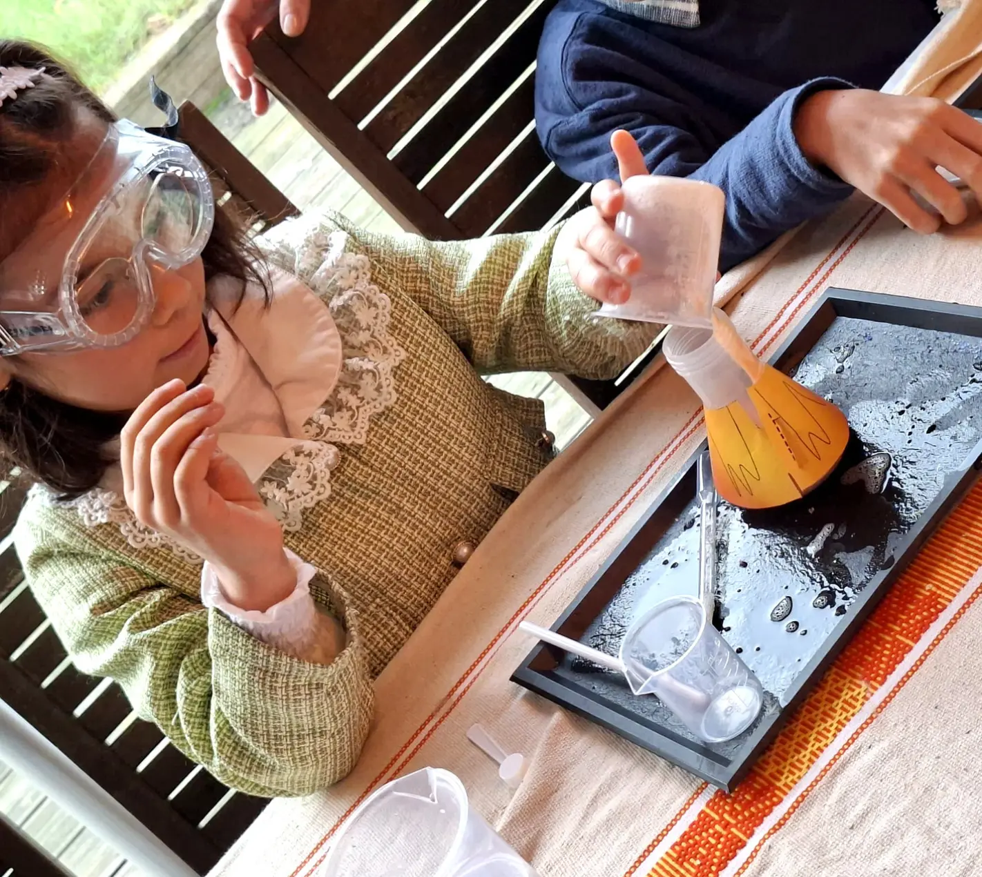 Enfant réalisant une expérience ludique autour de l’eau pendant un anniversaire à domicile