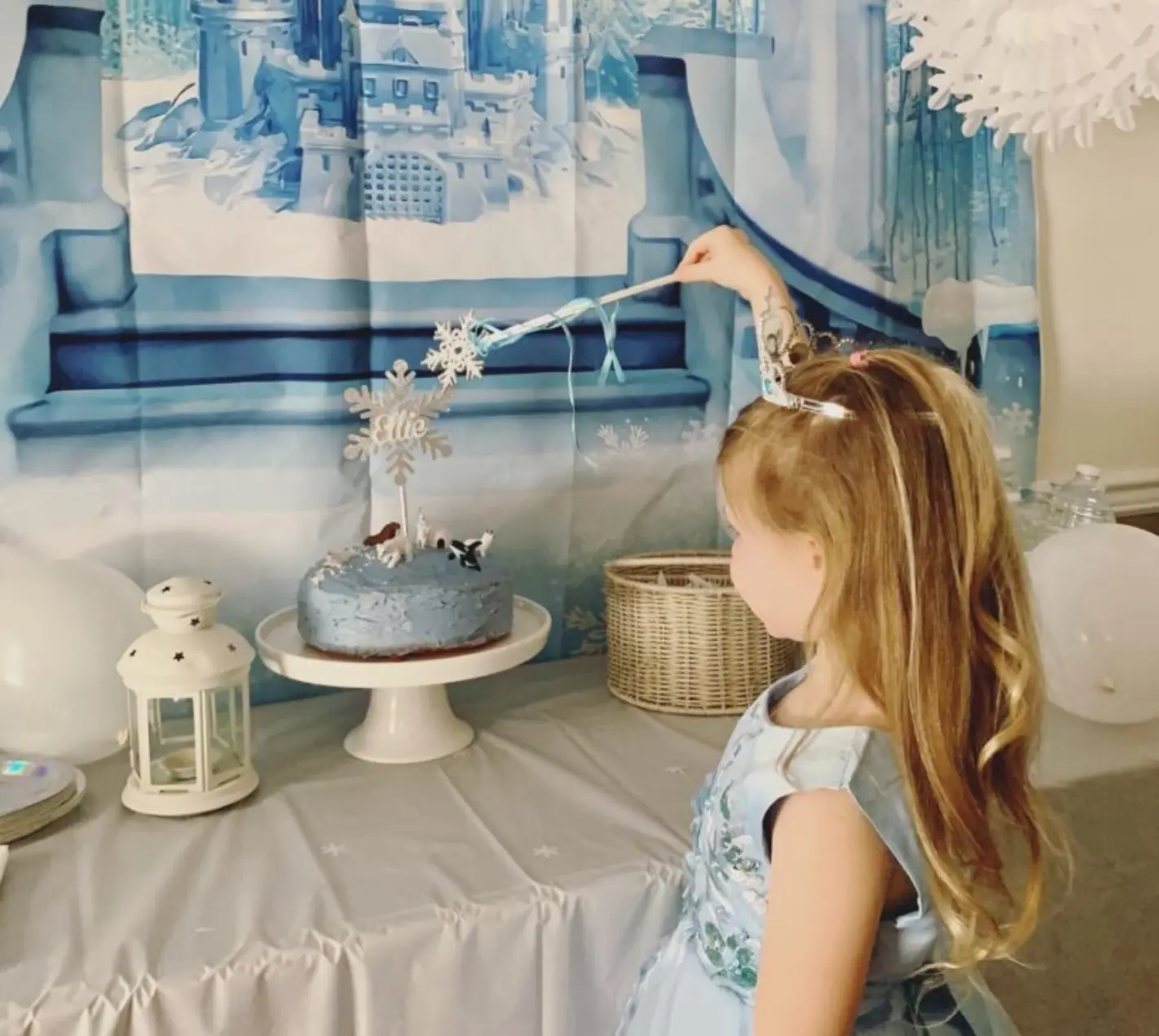 Décoration d’anniversaire enfant sur le thème Reine des Neiges avec gâteau et décor hivernal.